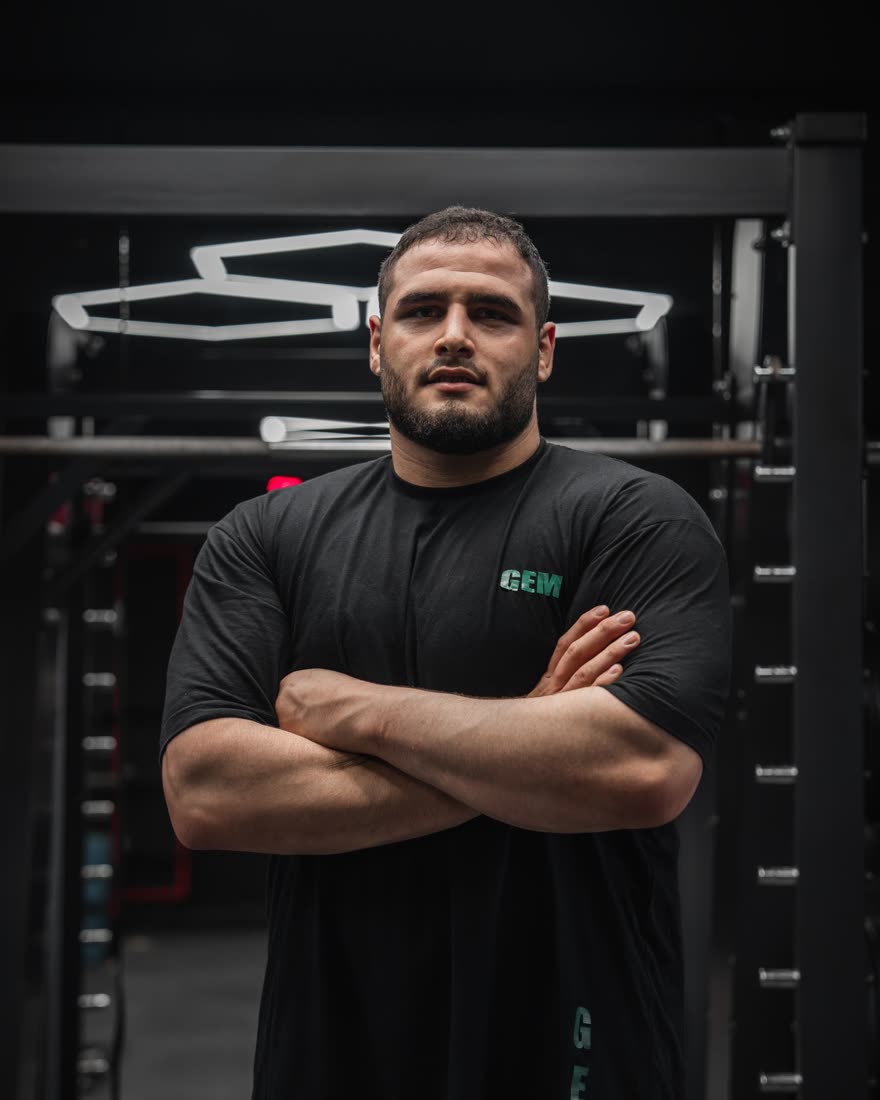 Marcus Cole standing in a dark gym with his arms crossed